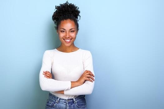 happy-african-american-woman-folded-arms-while-standing-over-studio-blue-background-image-free-photo